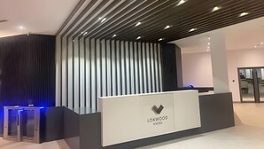 A reception desk with a modern design, a vertical slatted wall, and a logo for 'LOXWOOD HOUSE'. - Enjoy Luxury living on a budget at the heart of Accra (Accra)