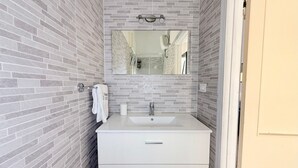A bathroom with a white sink, a mirror, and a towel rack. - SE232 - Senigallia, two-bedroom apartment with private courtyard (Senigallia)