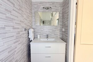 A bathroom with a white sink, a mirror, and a towel rack. - SE232 - Senigallia, two-bedroom apartment with private courtyard (Senigallia)