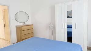 A bedroom with a bed, a dresser, a mirror, a fan, and a wardrobe. - SE232 - Senigallia, two-bedroom apartment with private courtyard (Senigallia)