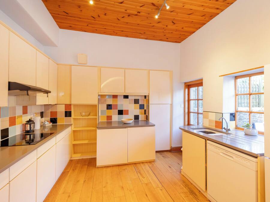 Une cuisine moderne avec un plancher en bois, un pare-feu en carreaux et une fenêtre offrant une belle vue.