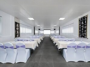 A conference room with rows of tables and chairs, white walls, and ceiling lights. - PIN Hotel Guangzhou Gongyuanqian Metro (Guangzhou)