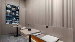 A modern room with a wooden bench, a small table with a bottle, and a shelf with various items. - PIN Hotel Guangzhou Beijing Road Pedestrian Street Gongyuanqian Metro Station Branch - Free Deliver Service to Guangzhou Baiyun International Airport & Free Deliver Service to Canton Fair Complex During Canton Fair Period (Guangzhou)