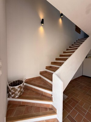 A staircase with wooden steps and white railings, leading to a landing with a basket and wall-mounted lights. - Pool • Climate - Golf - Near Saint-Tropez-Wi-fi (Roquebrune-sur-Argens)