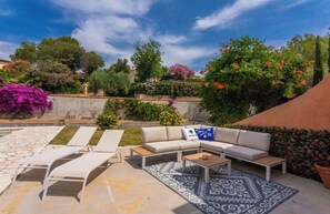 A patio with a sofa, lounge chairs, and a patterned rug. - Pool • Climate - Golf - Near Saint-Tropez-Wi-fi (Roquebrune-sur-Argens)
