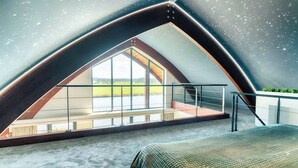 A room with a sloped ceiling, large windows, a bed, and a view of the outdoors. - Private Wellness Haven by the Vecht (Dalfsen)