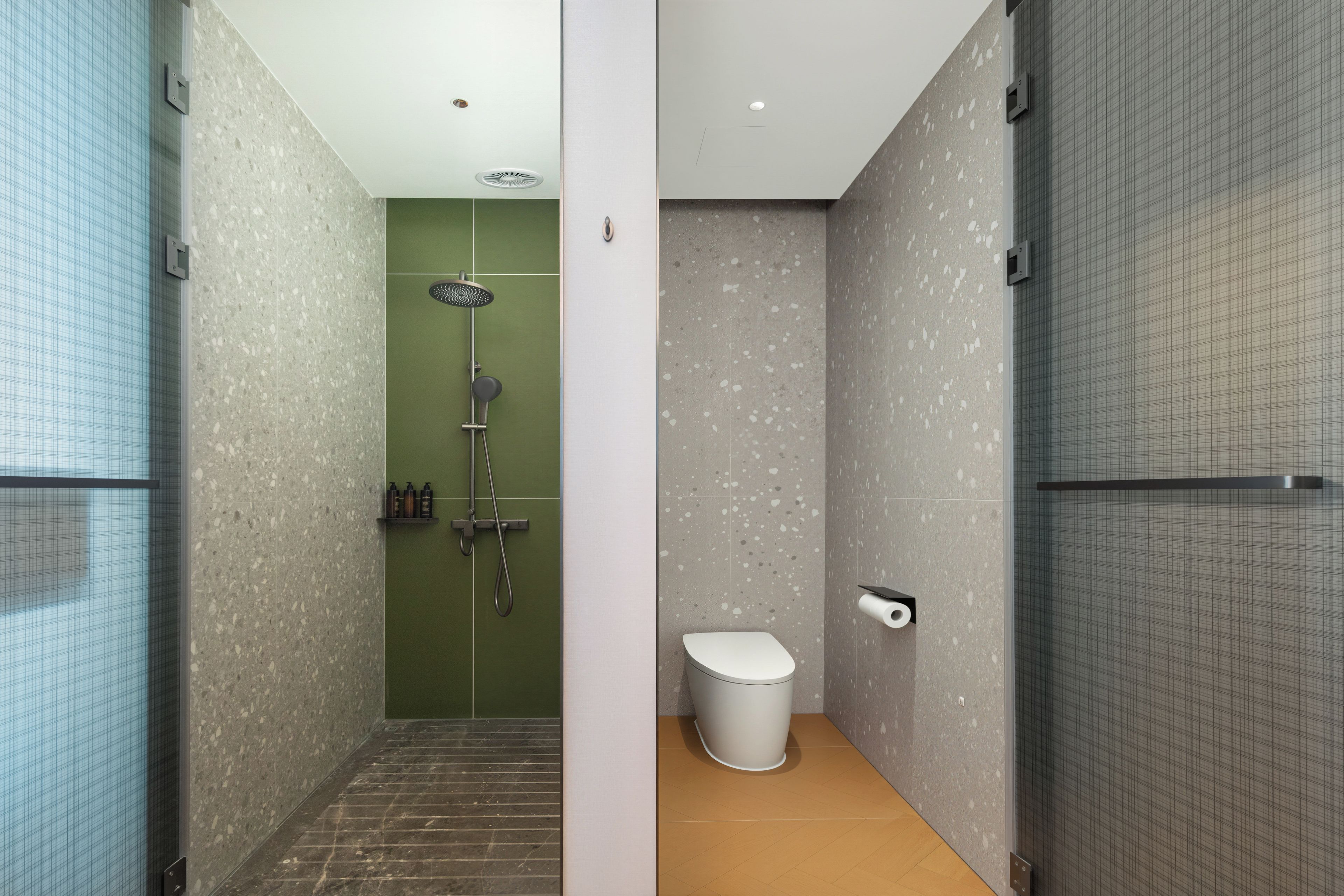 A modern bathroom with a shower, toilet, and a towel rack.