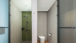 Un baño moderno con ducha, inodoro y perchero.