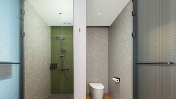 A modern bathroom with a shower, toilet, and a towel rack.