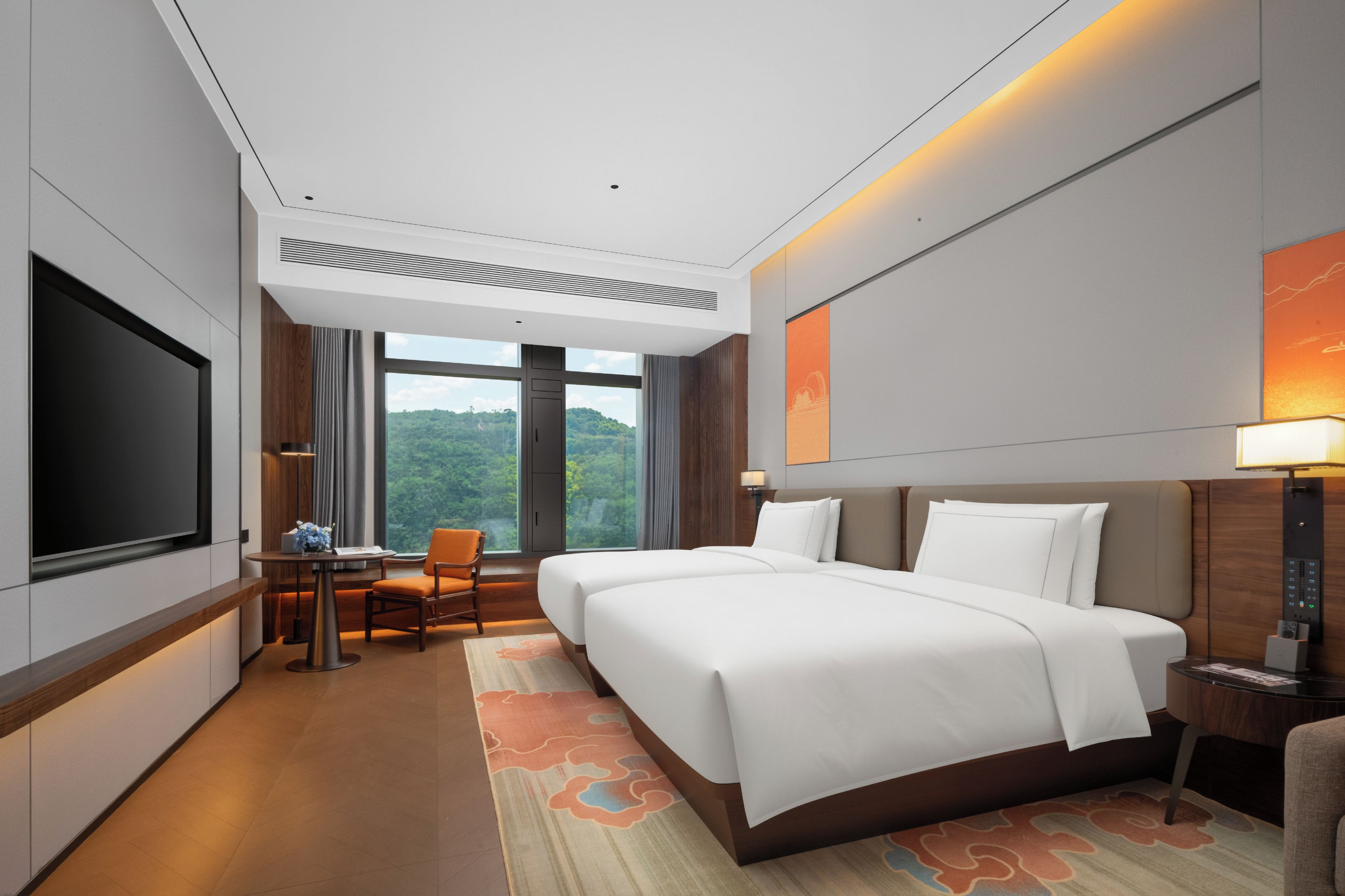 A hotel room with a large bed, a desk with a chair, a television, and a view of the outdoors.