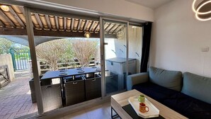 Una habitación moderna con una puerta de vidrio corredera que da a un espacio exterior, un sofá, una mesita de centro con una bandeja y vistas al exterior.