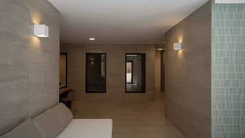 Habitación de hotel moderna con una cama grande, un escritorio y dos puertas que dan a otras habitaciones.