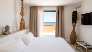 A hotel room with a large bed, a view of the beach, a statue, and a TV. - Hotel Casamore (Meria)