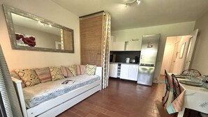 Ein gemütlicher Wohnbereich mit Sofa, Esstisch und einer Küchenzeile.
