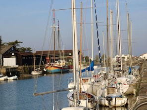 A marina with boats docked, a building with a sign, and a clear sky. - House near the sea - 5 guests (Noirmoutier-en-l'Île)
