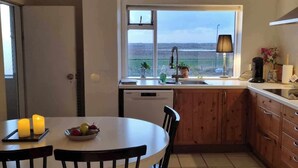 Una cocina con vistas, una mesa de comedor con sillas y un ventanal.