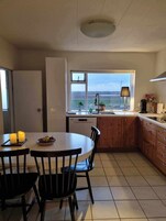 Una cocina con vistas, una mesa de comedor con sillas y un ventanal.
