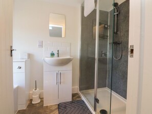 A modern bathroom with a glass shower enclosure, a white sink, and a toilet. - Cowside Farm (Settle)