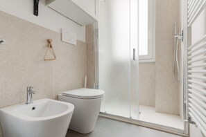 A modern bathroom with a bidet, toilet, and glass shower enclosure. - Cozy 53m2 apartment, perfect for 3 people, located on the raised ground floor.The accommodation is located in the Barona area, close to the Naviglio Grande and characterized by a rural soul with ancient farmhouses and recent urban redevelopment.The area  (Milan)