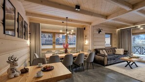 A wooden interior with a dining area, sofa, and a mounted animal head. - EcoWood Tatry by Jasek Premium (Poronin)