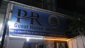 Un senyal per a 'Guest House' amb un logotip i text en diverses llengües.