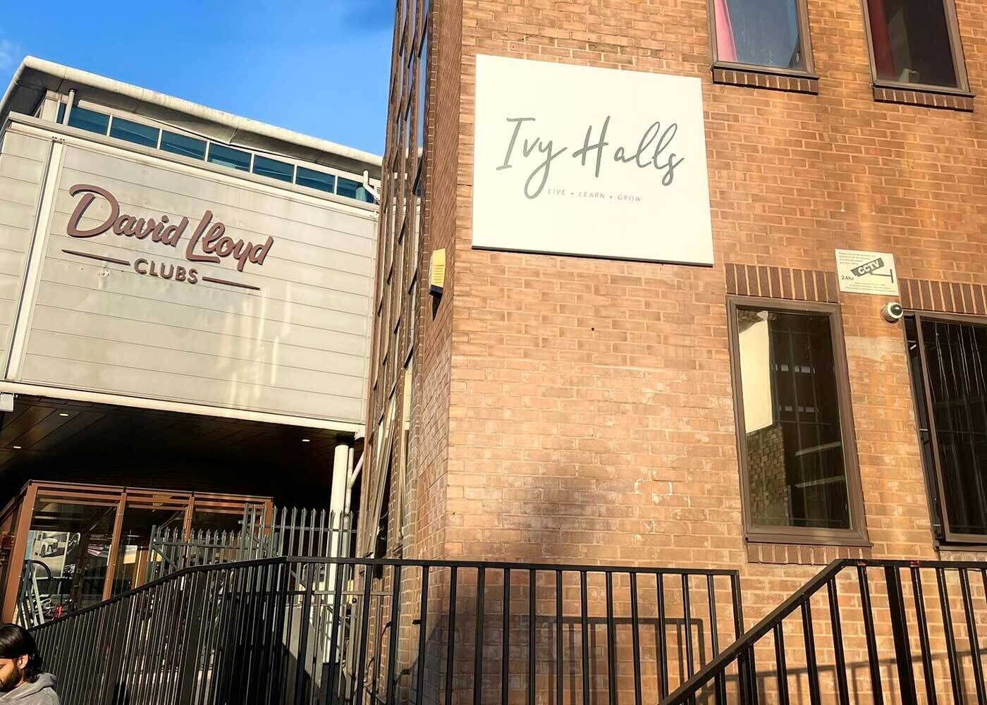 Ein Gebäude mit einem Schild für 'David Lloyd Clubs' und einem weiteren Schild für 'Ivy Halls'.