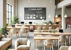 A modern office space with multiple workstations, a large 'COMMUNITY' sign, and natural light from large windows. - Student Only Non Ensuite Room Ivy Halls (London)