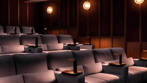 A cinema with rows of plush seating and wall-mounted lighting. - Student Only Non Ensuite Room Ivy Halls (London)