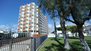 A multi-story residential building with balconies, a fenced courtyard, and trees. - EUROPEÑISCOLA SUPERIOR WITH PARKING (Peñiscola)