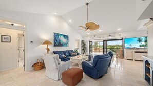 Un salón amplio con sofá, reposapiés y televisor.