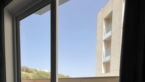 Een kamer met een grote glazen schuifpui die uitkomt op een balkon.
