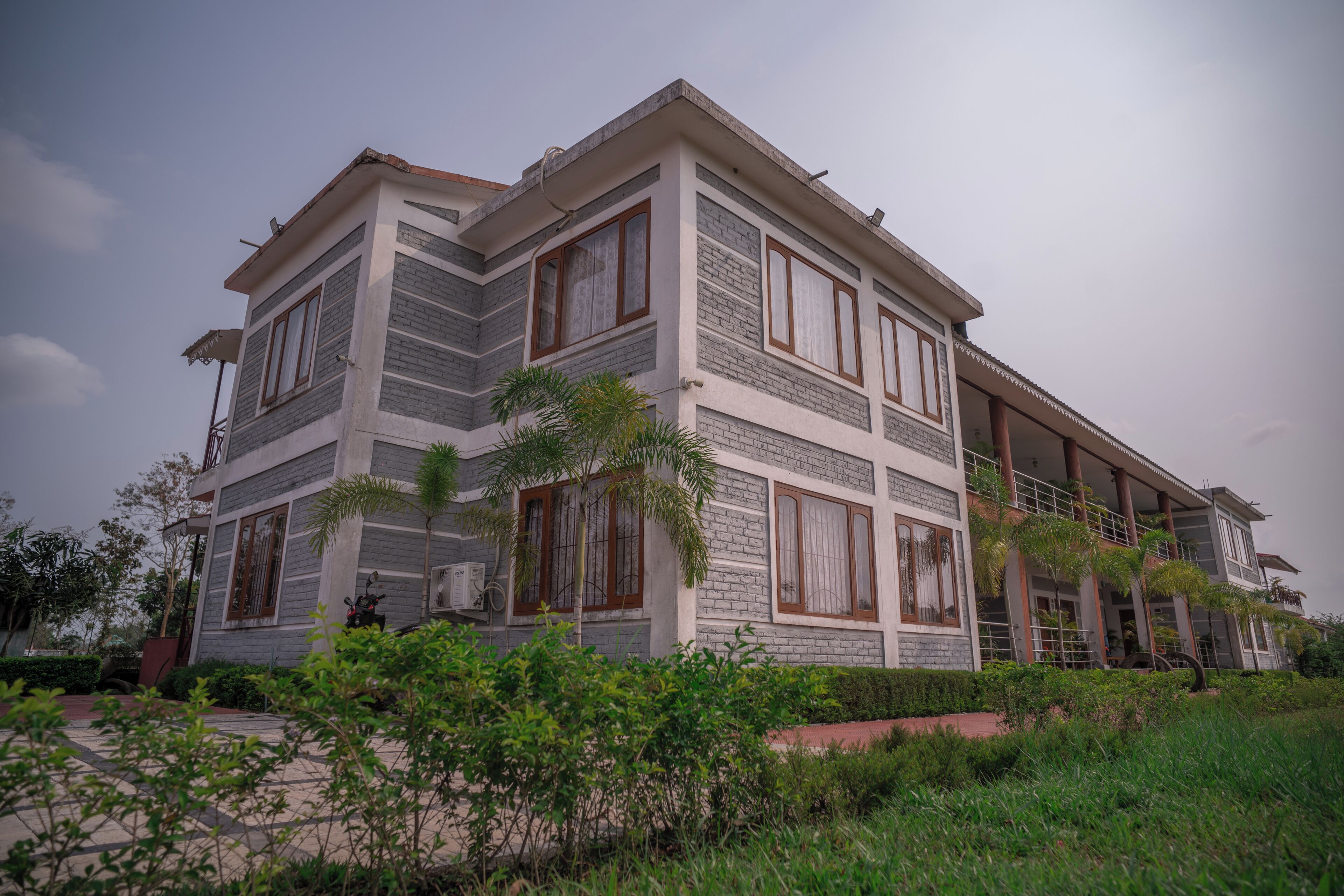 A multi-story building with a modern architectural design, featuring large windows and a balcony.