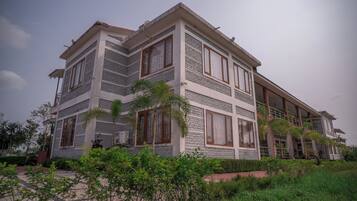 A multi-story building with a modern architectural design, featuring large windows and a balcony.