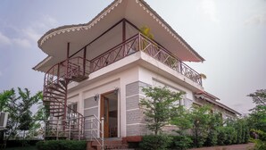 A two-story building with a balcony, a spiral staircase, and a large overhanging roof. - Resort Bihanga (Mal)