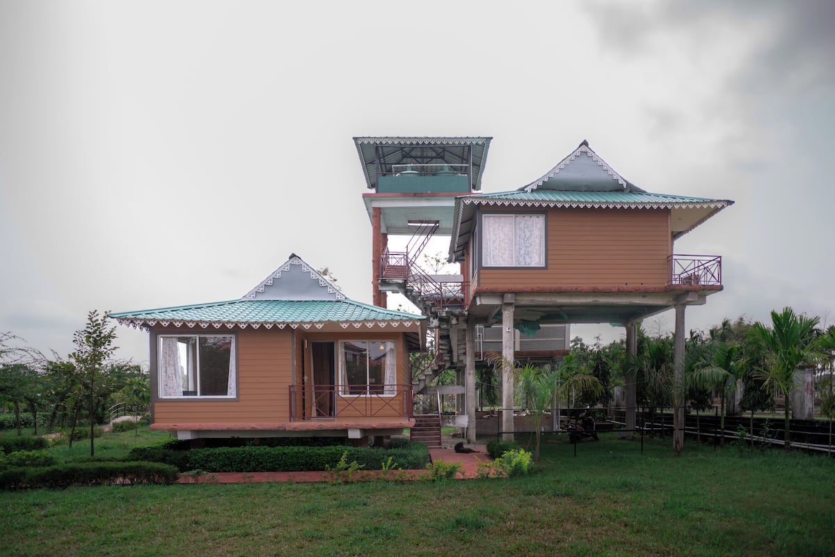 A two-story building with a balcony and a separate structure with a sloped roof.
