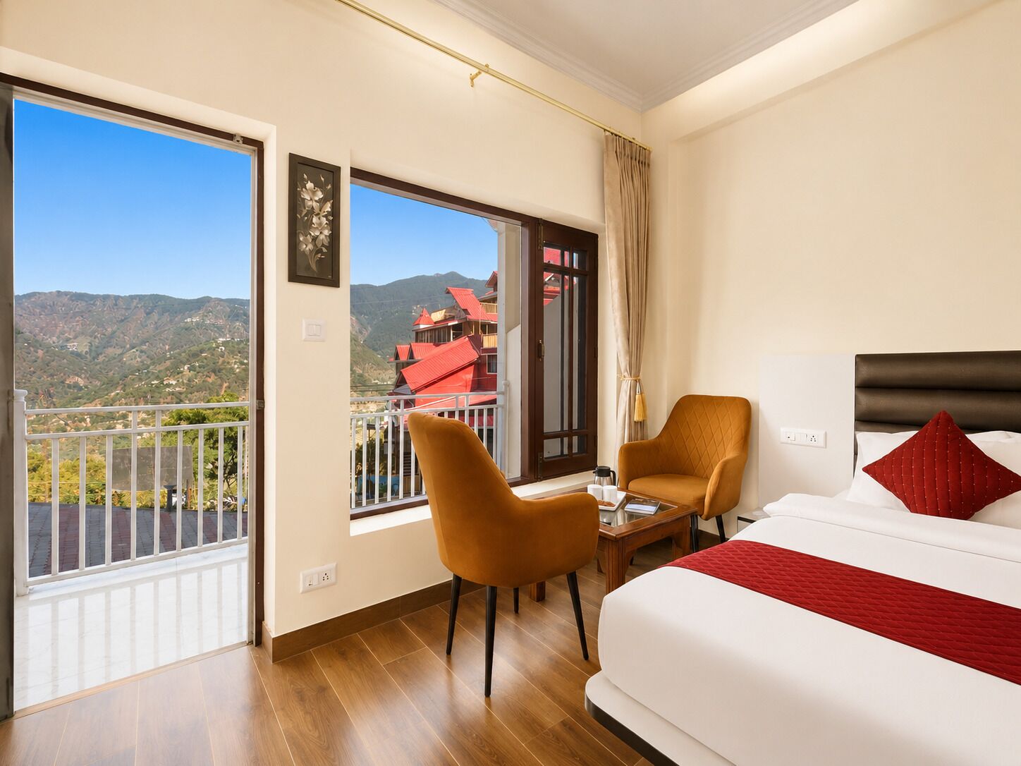 A hotel room with a balcony, a bed, a chair, and a table.