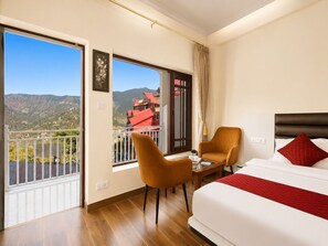 A hotel room with a balcony, a bed, a chair, and a table. - Hotel Luxeevista By Navodayans (Dalhousie)