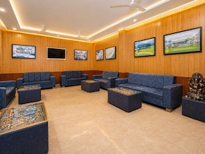 A modern lounge area with wooden paneling, multiple sofas, and a ceiling fan. - Hotel Luxeevista By Navodayans (Dalhousie)