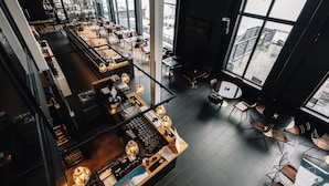 Een modern interieur met een bar, zitplaatsen en grote ramen.