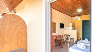 Een kamer met een houten plafond, een bed met handdoeken, een kleine tafel en een stoel.