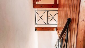 Eine Holztreppe mit Metallgeländer, die zu einer höheren Etage führt.
