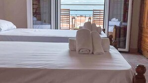 Ein Hotelzimmer mit Bett, einem Balkon mit Aussicht und einer Tür zum Außenbereich.