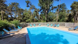 A rectangular swimming pool with a tiled edge, surrounded by a white metal fence. - The "Le Cosy" Apartment – Shared Pool (La Tranche-sur-Mer)