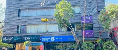 A multi-story hotel with signage for 'TBC,' 'ASTRA,' and 'FABHOTEL.'