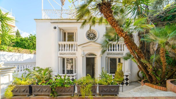 A white building with balconies, a large window, and potted plants. - Muta House (Sorrento)