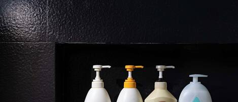 Cuatro botellas de productos de cuidado personal en una estantería.
