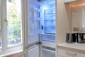 Eine moderne Küche mit einem eingebauten Kühlschrank, einem Fenster und einer Arbeitsplatte mit zwei Toastern.