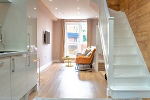 Ein modernes Interieur mit Treppe, einer Sitzecke und Blick durch ein Fenster.