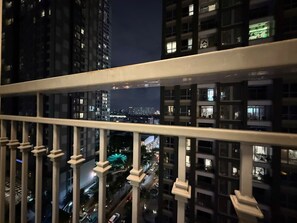 A nighttime cityscape with high-rise buildings, a Ferris wheel, and a busy street. - 2 Bedroom Apartment for Rent at Vinhomes Central Park (Thành phố Hồ Chí Minh)