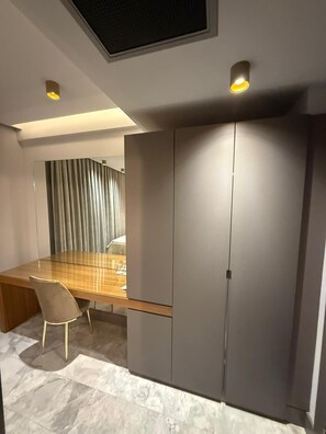 A modern room with a glass-top dining table, a single chair, and a wardrobe with a mirror. - The Pilgrim Ephesus Hotel (Selcuk)